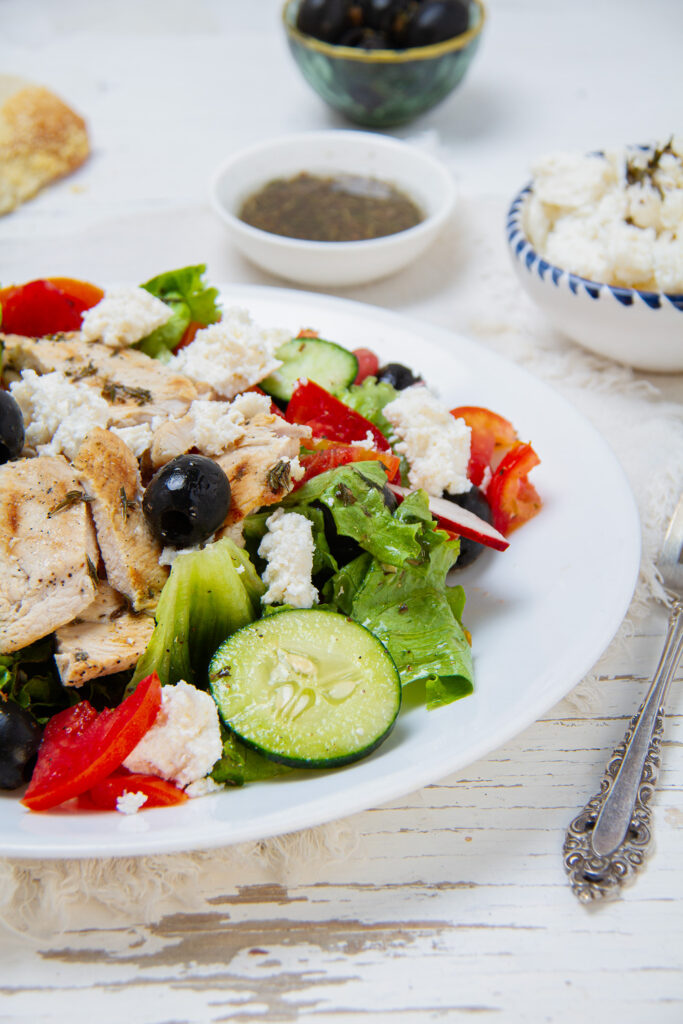 Greek Salad with Chicken served on white plate. 