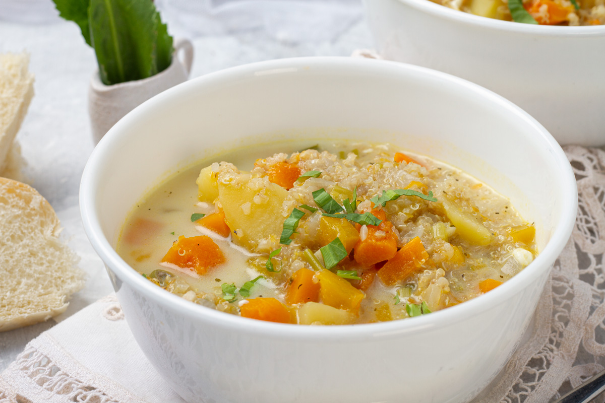 Quinoa soup, freshly made, served in a white bowl.