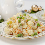 Traditional Venezuelan Ensalada de Gallina, creamy chicken salad, garnished with peas.