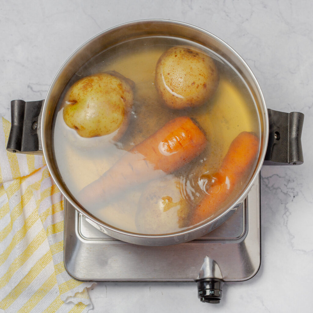 Boiling carrots and potatoes for Ensalada de Gallina.