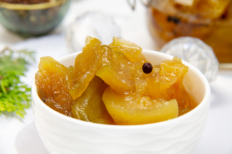 A bowl of homemade candied green papaya, a traditional Venezuelan Christmas dessert. This sweet and tangy treat is perfect for the holiday season!