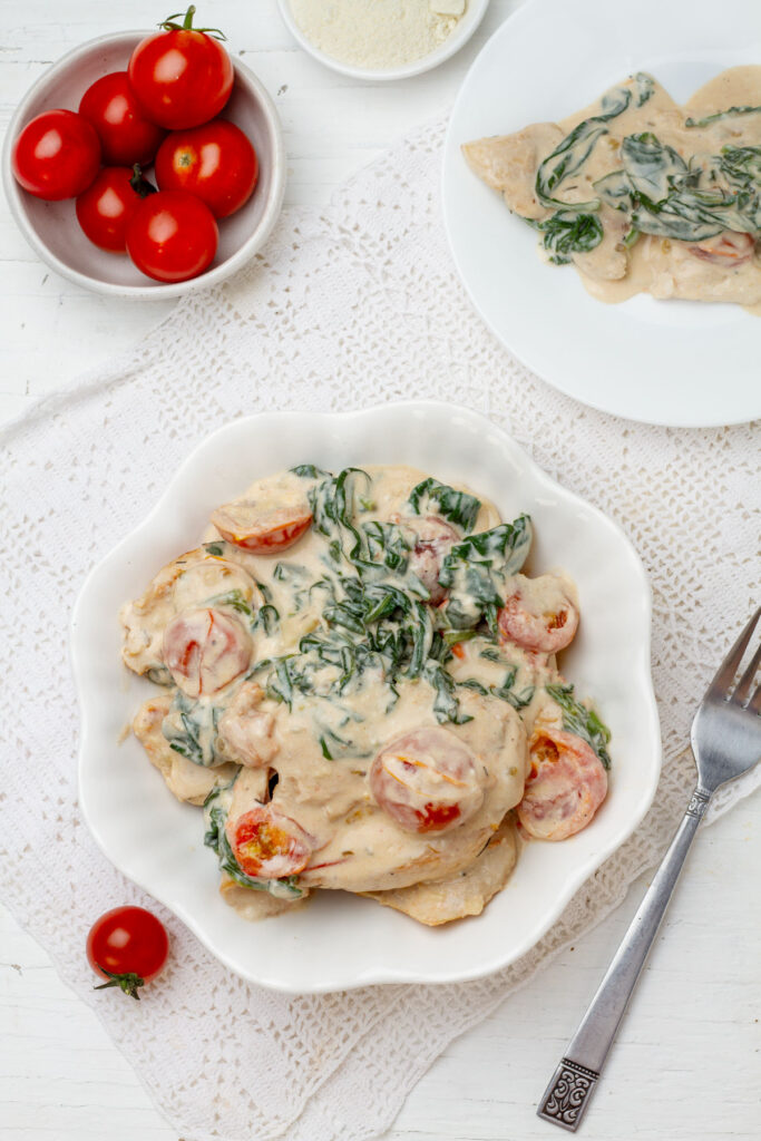 Top view of a delicious and flavorful dish of chicken cooked in a creamy tomato sauce with spinach.